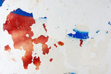 peeling white paint creating red and blue abstract design