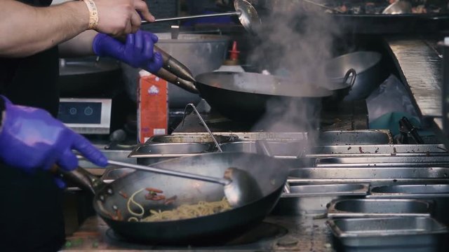 Wok cooking in wok pan, slow motion, close up 