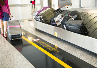 suitcases on conveyor belt of airport.