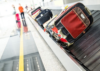 suitcases on conveyor belt of airport.