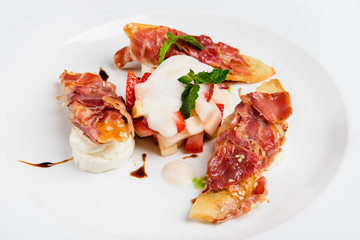 Baguette pieces covered with grilled bacon on plate served luxury.
