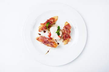 Baguette pieces covered with grilled bacon on plate served luxury.