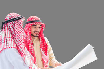Portrait of arabian engineer talking about construction job and verify the blueprint with commitment to success on isolated gray background