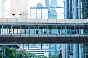 Fototapeta na wymiar Abstract modern city background with people walking in the bridge.