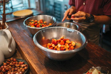Close up of man hands cutting the strawberries, preparation for cooking dessert