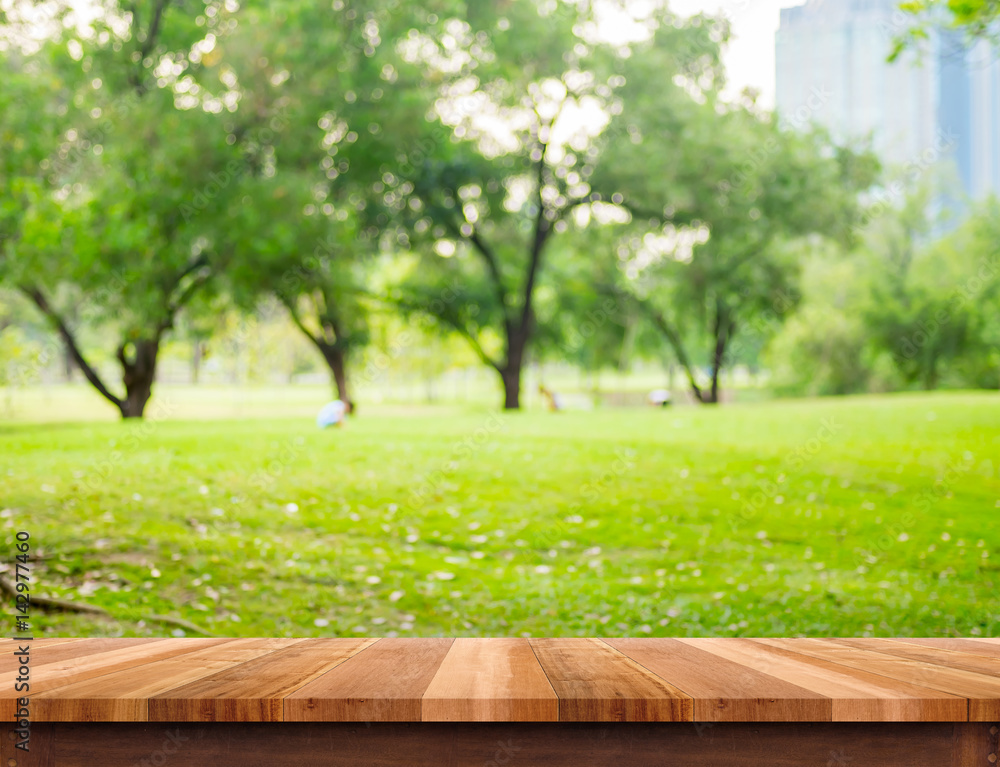 Poster empty brown plank wood table top with blur green tree in park with bokeh background, template mock u