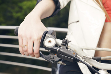 Female sitting on a motorcycle, hand on grip, outdoors, ready to go. No face.