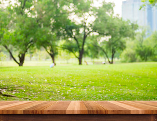 Empty brown plank wood table top with blur green tree in park with bokeh background, Template mock up for montage or display of product
