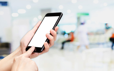 Hand click mobile phone with blur patient at hospital background bokeh light,White screen mock up template for adding your design or your text