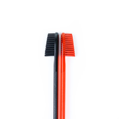 Closeup of two toothbrushes. For men and women. Full black and orange brush. Brush for the family. Isolated on a white background