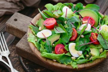 Fresh spring appetizing quail eggs, tomatoes arugula, pine nuts, swiss chard salad