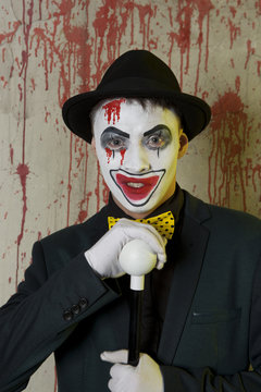 Evil clown wearing a bowler hat on wall