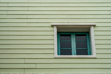 Green windows on old wooden wall