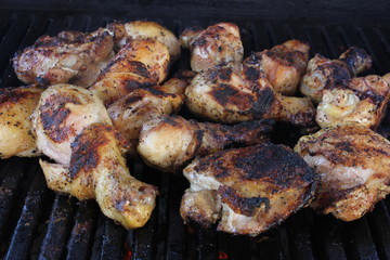 Assortment of chicken on a charcoal BBQ grill