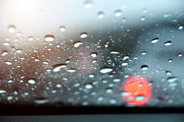Abstract image of rain drops on car side view mirror and window.