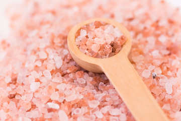 Fototapeta na wymiar Scattered pink Himalayan salt, wooden spoon, spa, health, wellness concept
