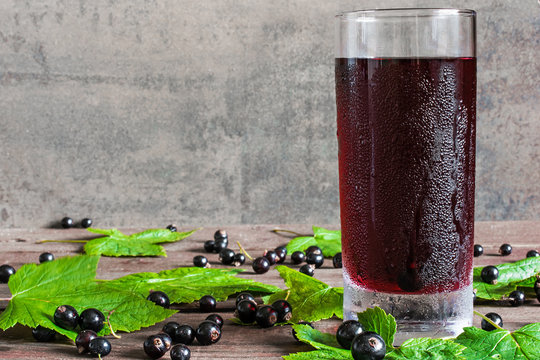 glass of cold black currant juice with fresh berries