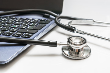 Close-up of stethoscope and laptop computer