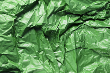 Crumpled textured paper saturated green  background