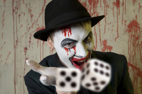 Evil clown playing with dice