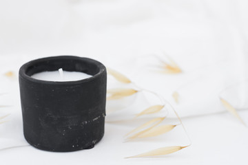 Black stone candle, dry plants, wild oats on white background, styled stock image for social media, marketing, websites