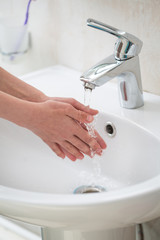 The boy is washing his hands