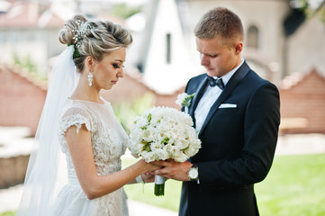 Stylish wedding couple walking in love on green lawn.
