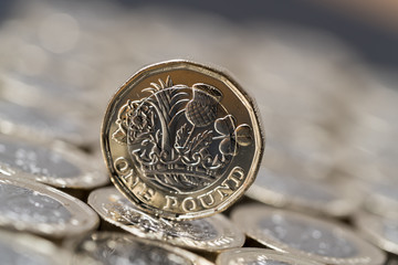 new pound coin introduced in Britain in 2017, front, on a layer of coins