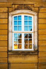 Fototapeta na wymiar Old white window and yellow building facade, Copenhagen, Denmark