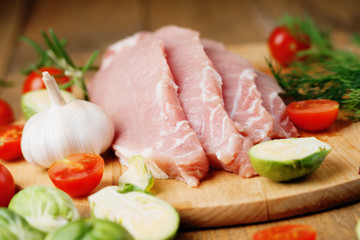 Fototapeta na wymiar Slices of raw pork meat and vegetables 