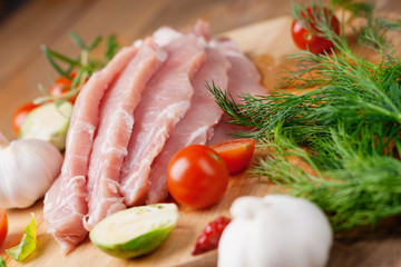 Slices of raw pork meat and vegetables 