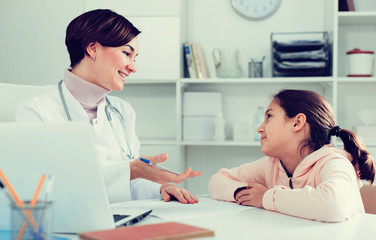 Fototapeta premium Doctor fills patient card for girl