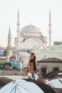 Couple in love standing on roof with view of Blue Mosque at background. Old Istanbul Sultanahmet