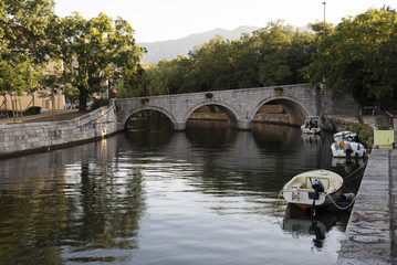 Fototapeta na wymiar Old stone bridge over canal on Adriatic coast