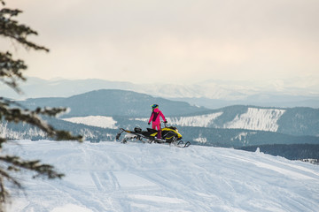 Fototapeta na wymiar Rider on the snowmobile in the mountains