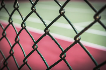 Fototapeta premium Close-up wire mesh steel with cort tennis background.