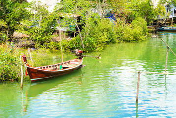 Long tail boat with fishing village