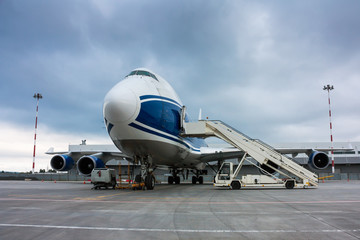 Fototapeta na wymiar Cargo wide body plane and aircraft passenger loader near terminal