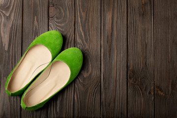 Green women's shoes (ballerinas) on wooden background.