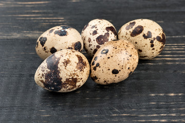 Some raw quail eggs on a wooden background
