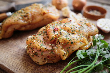 Spicy chicken breast with parsley and garlic on wooden board