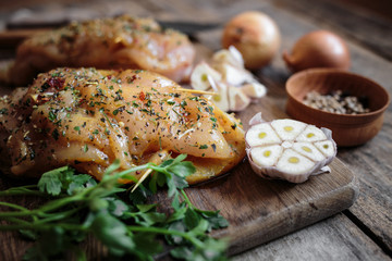 Spicy chicken breast with parsley and garlic on wooden board