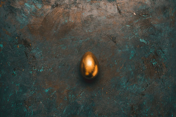 Top view of golden chicken egg on tabletop. Happy Easter concept