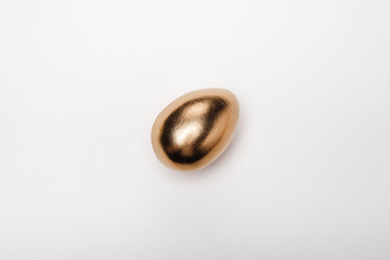 Close-up top view of golden Easter egg on white background, Happy Easter concept