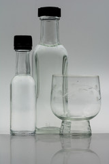 Bottiglie e bicchiere riflessi.