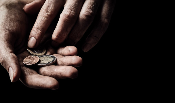 Hands of beggar with few coins