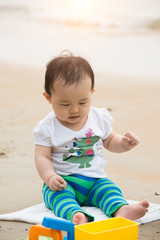 asian baby playing on beach
