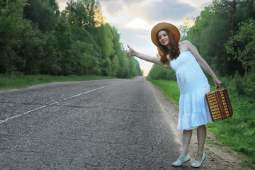 Fototapeta premium girl in a white sundress and wicker suitcase walking on rails