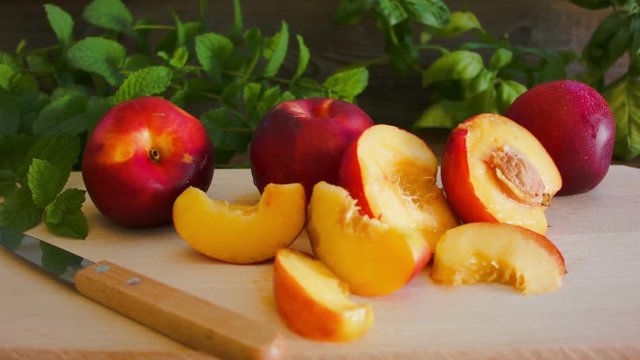 Ripe tasty nectarine on the wooden board on the table