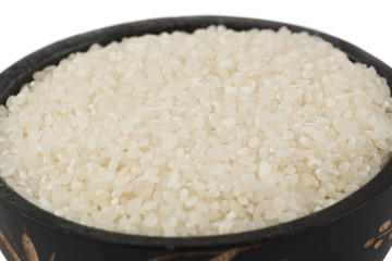Rice in wooden bowl. Uncooked rice grains